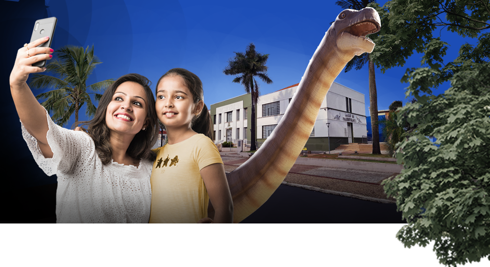 Mãe e filha tirando foto com dinossauro